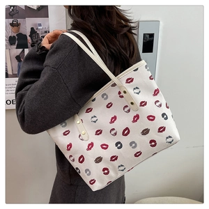Detail view of large tote bag featuring stylish red lip prints and golden rivet accents