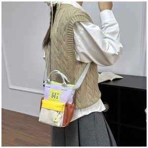 Detail view of multi-color canvas crossbody bag with Lego-style block decorative panel