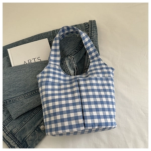 Close-up of blue and white checkered tote bag with two front pockets and canvas texture
