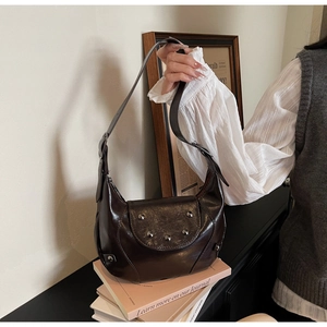 Detailed macro shot of dark brown saddle bag with silver rivets on vintage leather