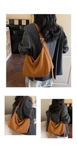 Detail of a brown faux leather hobo bag showing the wide strap and silver metal buckle
