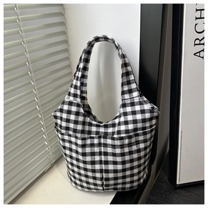 Detail of checkered canvas tote bag with dual front pockets on a minimalist background