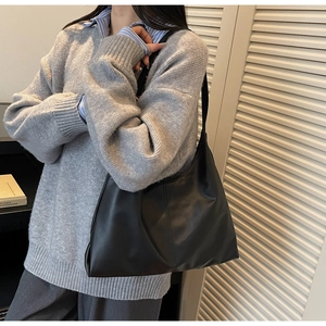Detail view of the black matte tote bag showing the vertical stitching and large capacity