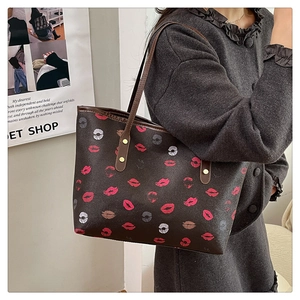 Detailed view of large tote bag with trendy lip print pattern on brown leather surface