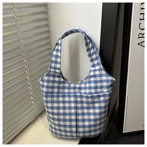 Detailed view of the blue and white checkered canvas tote bag with dual front pockets