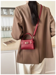 Rückansicht einer roten Handtasche mit Lychee-Struktur, Golddekor und Schultergurt