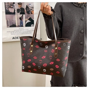 Detail view of large tote bag with brown base and vibrant red lipstick print texture