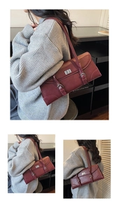 Detailed view of a vintage burgundy baguette bag with silver twist lock and buckle straps