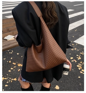 Détail du grand sac hobo tressé marron foncé avec texture en cuir fin en style de rue