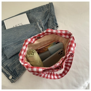 Interior view of red checkered bucket bag showing spacious storage for daily essentials