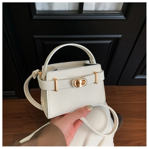 Detailansicht der weißen Handtasche aus Leder mit Narbung und goldenem Drehverschluss