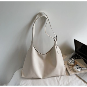 Detailed shot of beige hobo bag with adjustable strap and central seam texture