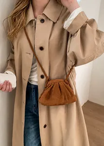 Brown pleated cloud bag in suede finish styled with a khaki trench coat for a minimalist look