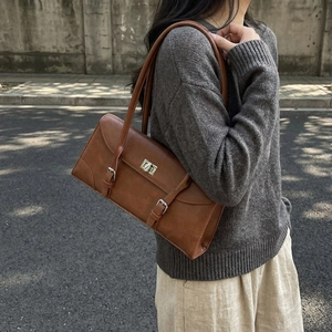Vintage brown leather shoulder bag with silver turn-lock and retro baguette design