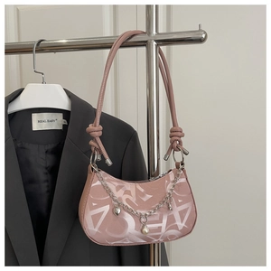 Detail of pink faux leather baguette bag with silver heart chain and pearl charms