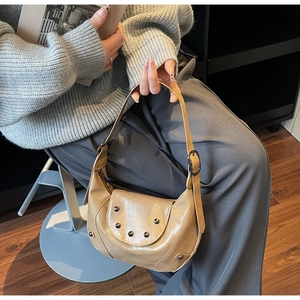 Detail of khaki crescent moon bag with silver rivets and adjustable shoulder strap