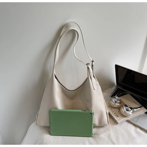 Minimalist beige hobo bag detail with iPad and art book showing large capacity