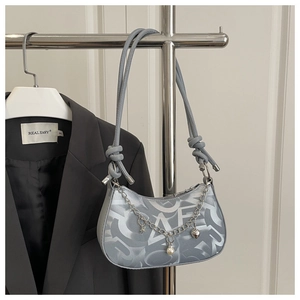 Detail of grey silk half-moon bag with silver chain, star charms and heart pendants
