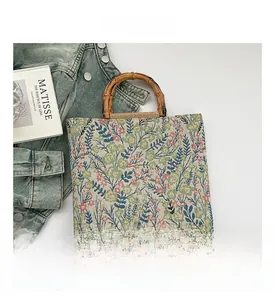 Close-up of floral tapestry tote bag featuring natural bamboo handles and textured fabric