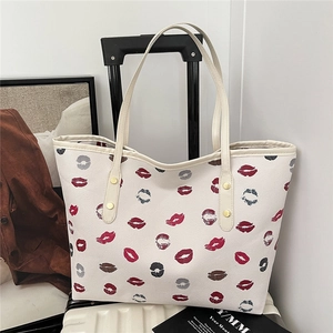 Chic off-white tote bag with trendy red lip prints and stylish gold hardware accents
