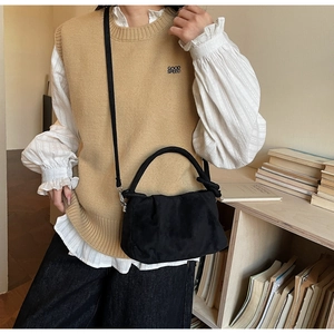 Detail of minimalist black suede cloud bag with soft texture and adjustable shoulder strap