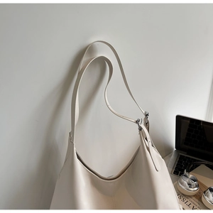 Minimalist beige oversized tote bag with adjustable strap and smooth faux leather texture