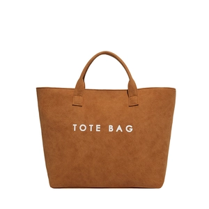 Minimalistische braune Tragetasche aus Wildleder mit weißem Tote Bag Schriftzug auf Weiß