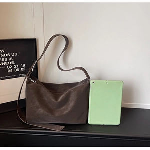 Detail view of large brown suede tote bag showing texture and tablet size reference