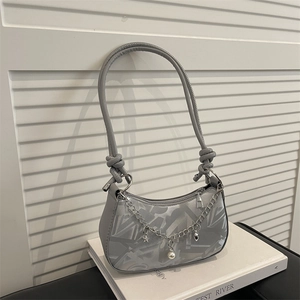Chic grey minimalist hobo bag with silver star and pearl charms on white book prop