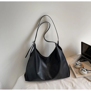 Detail shot of black minimalist hobo tote bag with silver buckle and adjustable strap