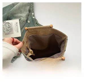Detail view of spacious beige fabric tote bag with bamboo handles and floral print