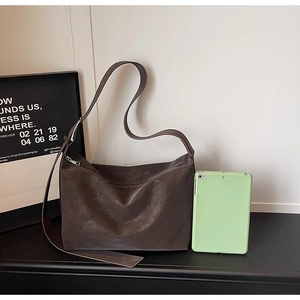 Detail view of large dark brown tote bag showing adjustable wide strap and storage capacity