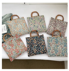 Detail of six floral jacquard tote bags featuring unique bamboo handles and woven texture