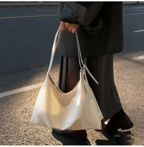 Outdoor street style view of minimalist large-capacity beige soft leather tote bag details