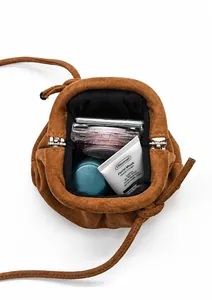 Detailed interior of a brown suede mini cloud bag showing storage for daily cosmetics