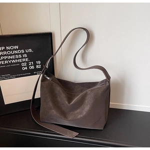 Detail of dark brown hobo tote bag featuring wide shoulder strap and matte leather finish