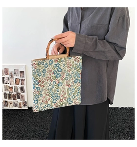 Close-up of floral jacquard tote bag with natural bamboo handles on a stylish background