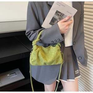 Detailed shot of avocado green pleated corduroy bag with knot handle and long strap