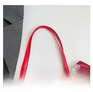 Détail de la poignée de sac de mariée rouge avec nœud en satin et motif double bonheur