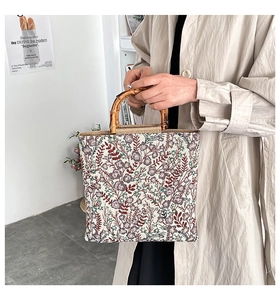 Close-up of floral embroidery tote bag featuring natural bamboo handles and vintage patterns