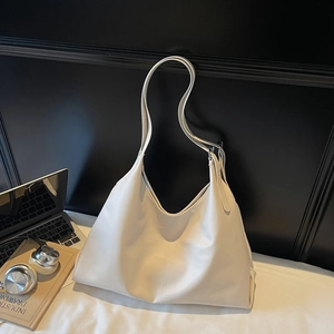 Detail of minimalist cream tote bag with adjustable strap and soft matte faux leather texture