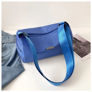 Detailed view of blue plaid barrel bag with silver metal logo and nylon strap