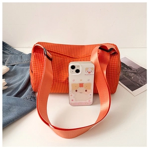 Detail view of orange plaid nylon duffel bag showing a wide strap with a black plastic buckle
