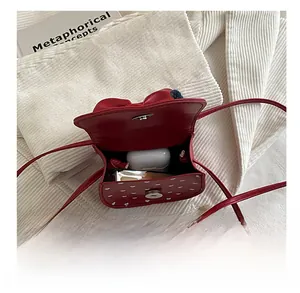 Detail view of red mini crossbody bag interior showing storage for small items and accessories