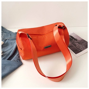 Detail view of orange checkered nylon barrel bag with black logo patch and shoulder strap