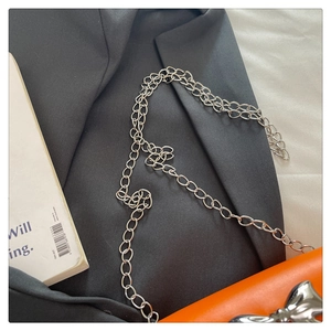Détail du mini sac carré orange vif avec noeud en métal argenté et bandoulière