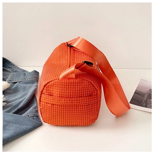 Detail view of bright orange checkered gym bag with adjustable nylon strap and zipper