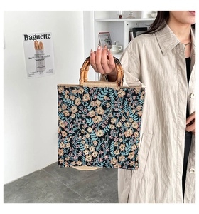 Detail of floral embroidery fabric and natural bamboo handles on the large tote bag