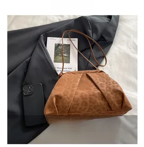 Detail of leopard print pleated shoulder bag showing suede texture and leather strap