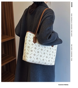 Model wearing a large vintage printed tote bag with leather trim on shoulder